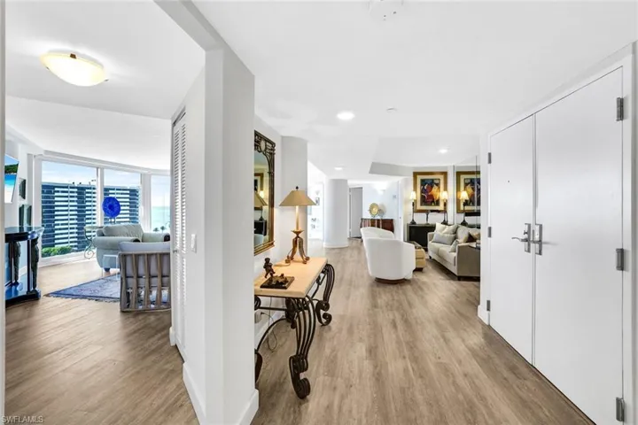 Hall with a wall of windows, wood finished floors, and baseboards