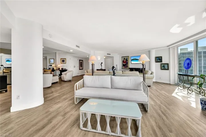 Living area with visible vents, light wood-style flooring, and baseboards