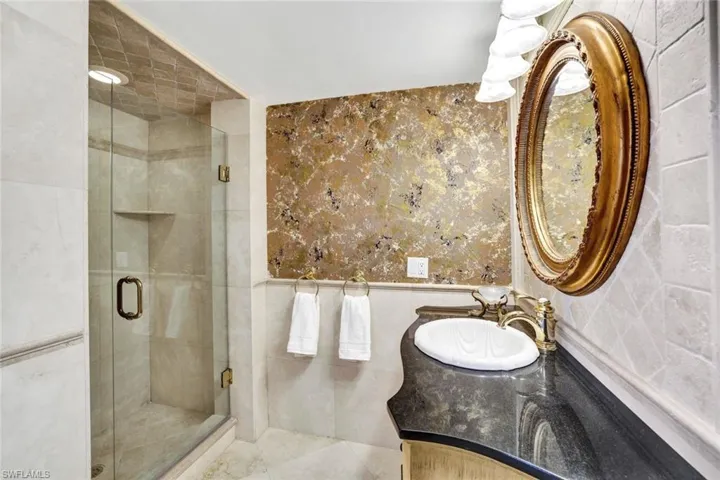 Full bath with a shower stall, tile walls, and vanity