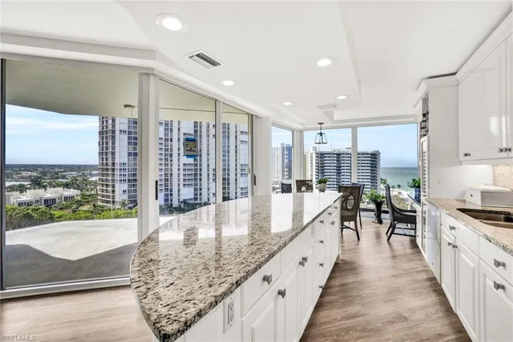 Kitchen featuring a sink, expansive windows, white cabinets, visible vents, and recessed lighting