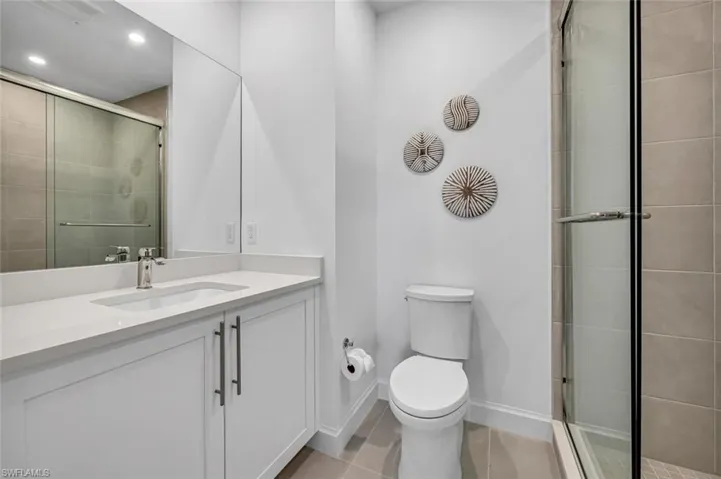 Bathroom with vanity, tile patterned floors, toilet, and walk in shower