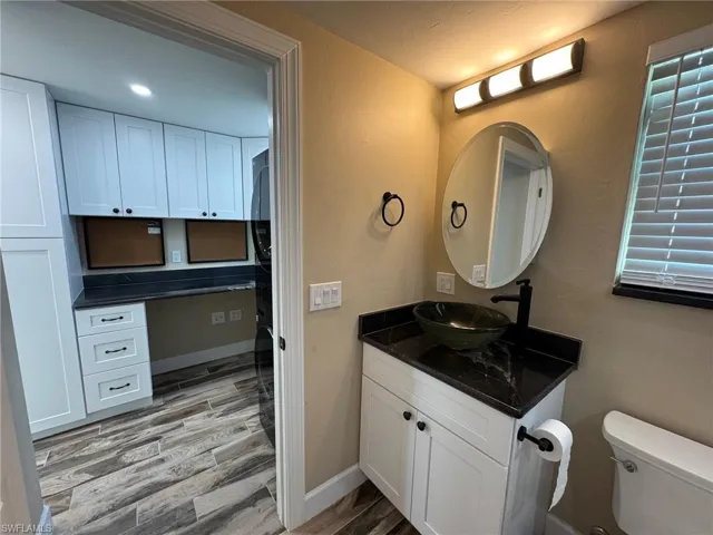 Bathroom featuring hardwood / wood-style floors, vanity, and toilet