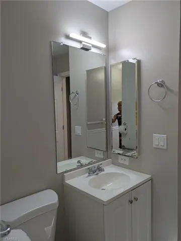 Bathroom vanity featuring an integrated sink, polished chrome faucet, and white cabinetry