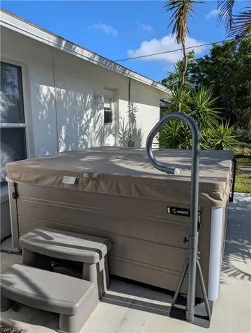 Outdoor spa with a protective cover, integrated steps, and a handrail