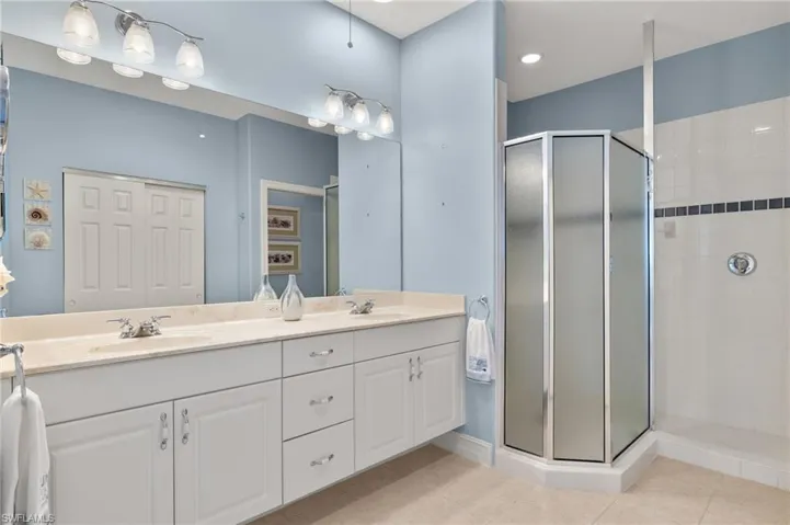 Primary bathroom features dual sinks and walk in shower.