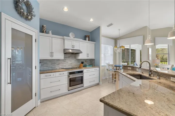 Remodeled chef's kitchen with granite counter tops, glass backsplash, walk in pantry and stainless steel GE appliances.