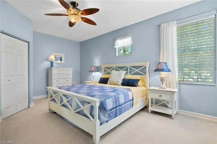 Large guest bedroom with king sized bed, ceiling fan and walk in closet.
