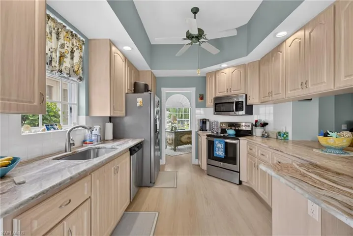 Kitchen featuring wood-finish cabinetry, light-toned countertops, and stainless steel appliances