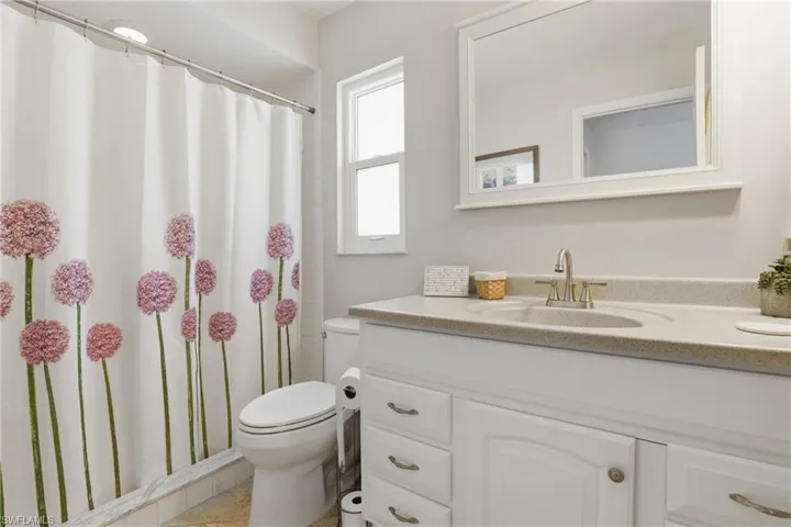 Primary Bath has Shower, White Cabinetry & Corian Countertop.