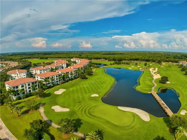 Aerial perspective showcasing residences bordering a golf course with multiple greens and sand traps