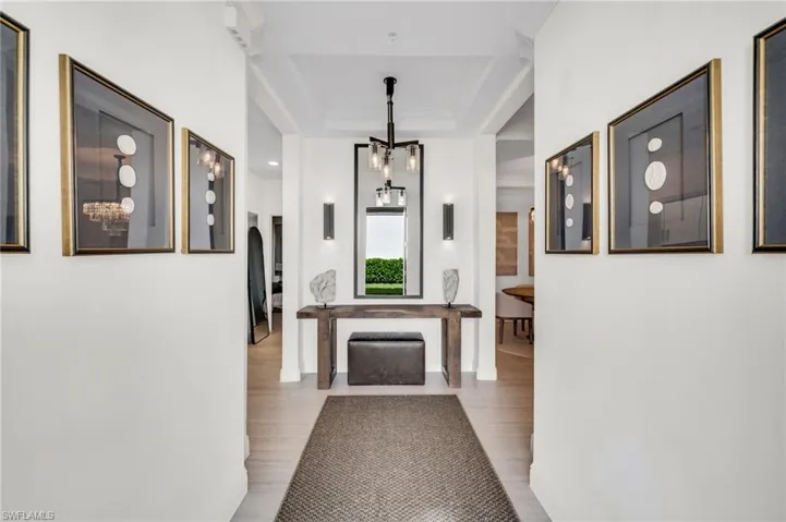 Foyer featuring crown molding, hardwood-style flooring, and a contemporary chandelier