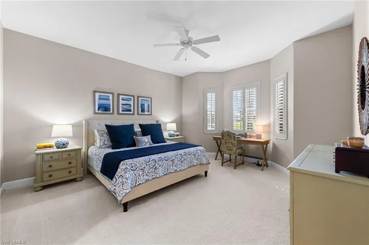 Bedroom featuring carpet floors, an office area, and ceiling fan