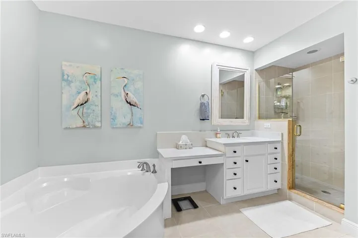 Bathroom with vanity, a garden tub, a stall shower, light tile patterned flooring, and recessed lighting