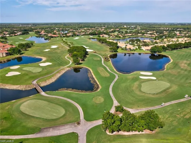 Aerial overview of property's location featuring a golf club, a large body of water, and nearby suburban area