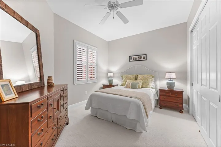 Bedroom featuring a closet, light colored carpet, and a ceiling fan
