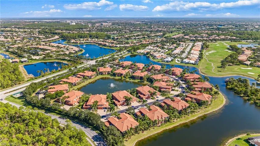 Aerial perspective of suburban area featuring a nearby body of water and a golf club