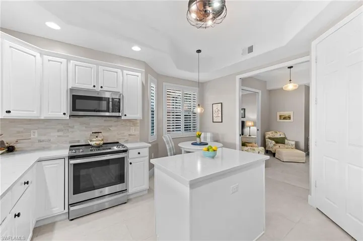 Kitchen featuring stainless steel appliances, white cabinetry, a center island, and recessed lighting