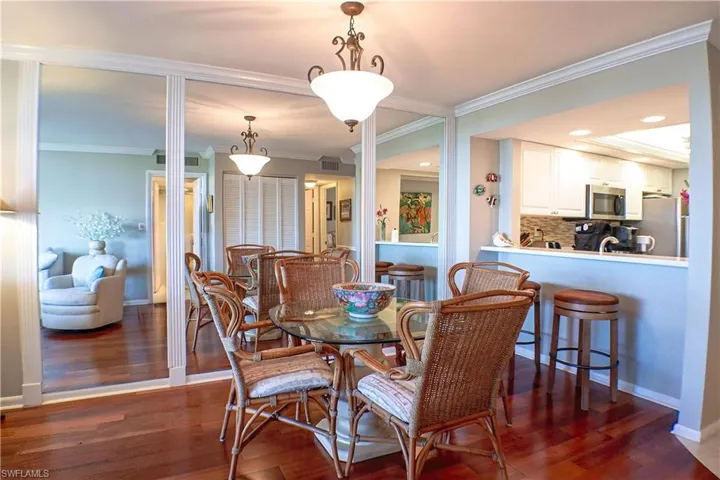 Dining area with crown molding and dark hardwood / wood-style floors
