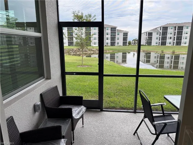Screened-in patio with concrete flooring, dark metal framing, and direct water frontage