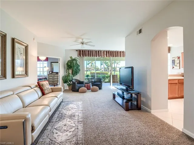 Living room featuring light carpet, a healthy amount of sunlight, and ceiling fan