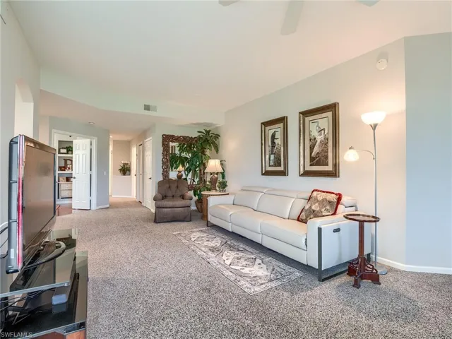 Living room featuring carpet and ceiling fan