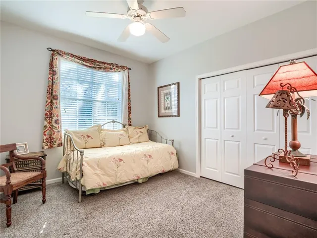 Carpeted bedroom featuring a closet and ceiling fan