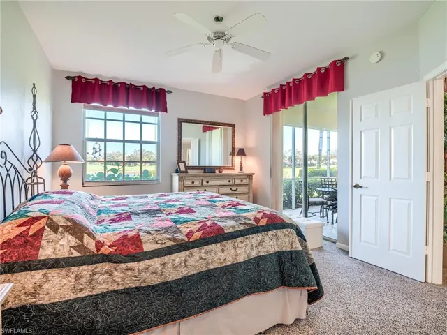 Carpeted bedroom featuring access to outside and ceiling fan