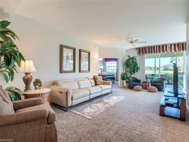 Carpeted living room featuring ceiling fan