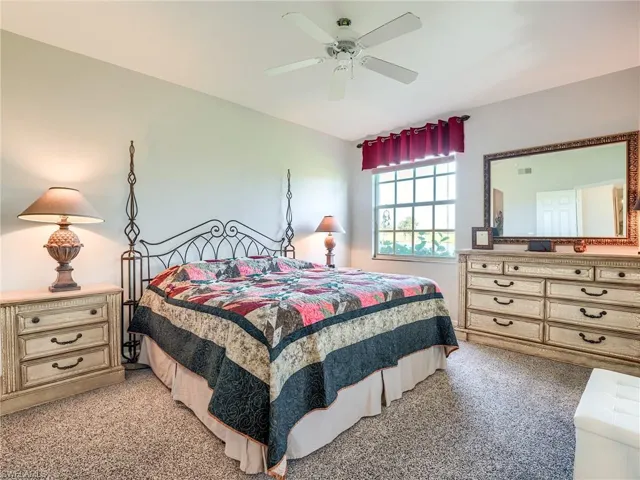 Carpeted bedroom featuring ceiling fan