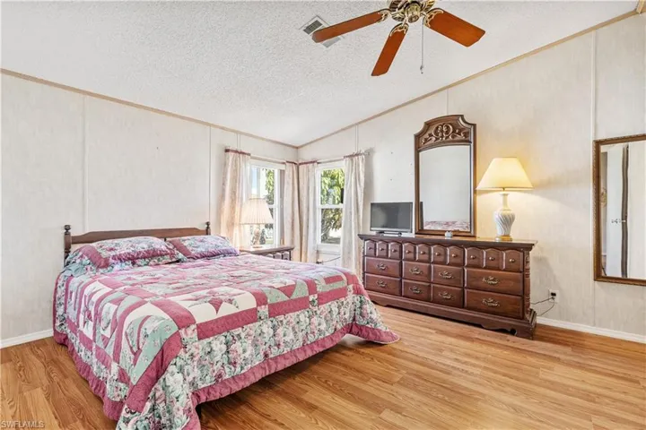 Bedroom featuring crown molding, light wood finished floors, and a ceiling fan