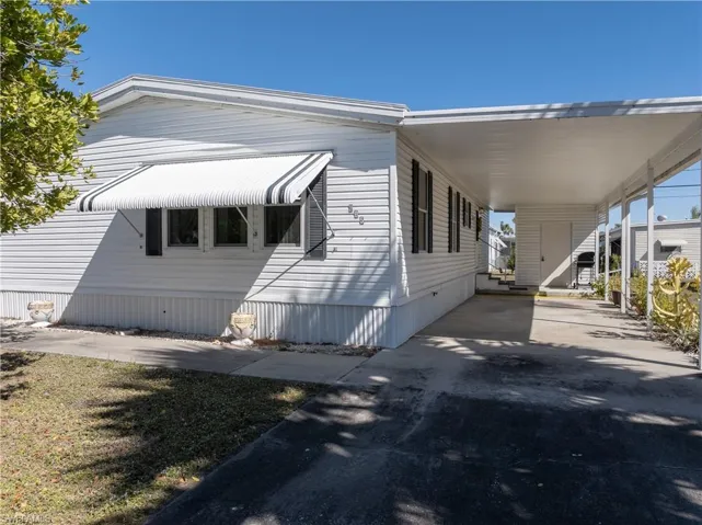 View of home's exterior featuring an attached carport and driveway