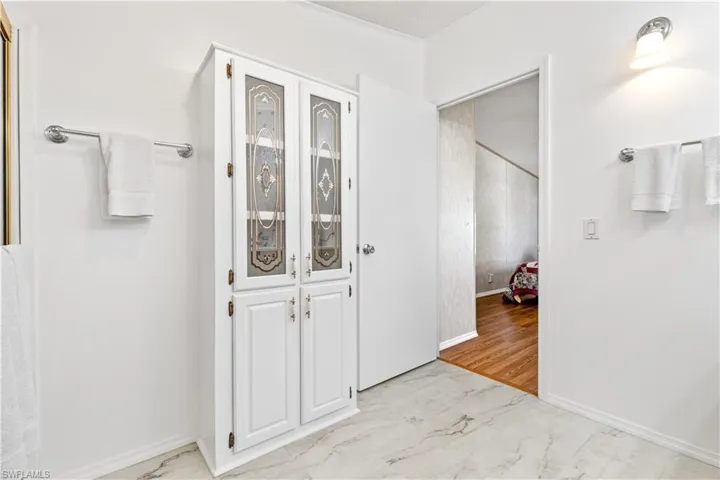 Bathroom featuring light marble finish flooring and a textured ceiling