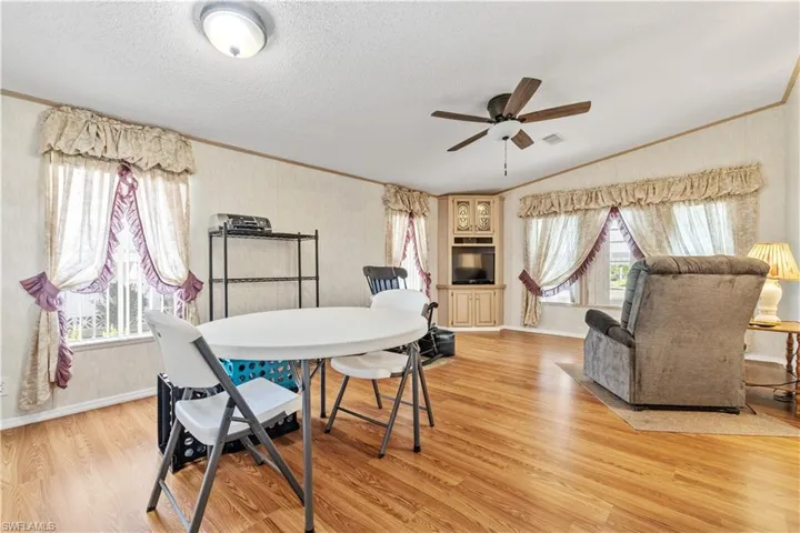Dining room featuring ornamental molding, a ceiling fan, and light wood-style floors