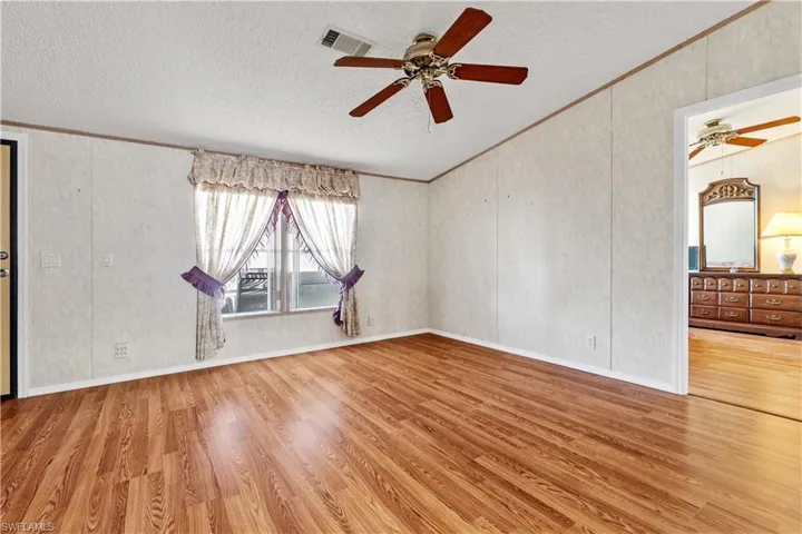 Unfurnished room with a ceiling fan, ornamental molding, and wood finished floors