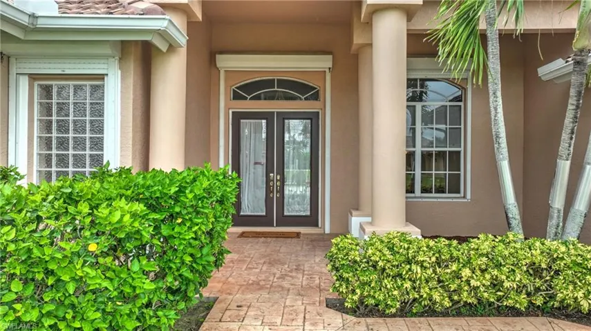 Stamped concrete walkway leading to double entry doors with decorative glass inserts