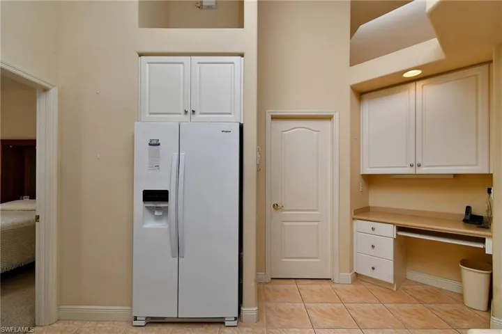 Built-in desk area with white cabinetry, integrated task lighting, and a neutral-toned countertop