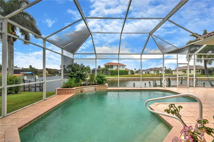 Screened outdoor swimming pool area featuring a water feature, an integrated planter, and a tiled pool deck