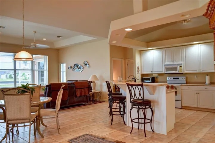 Kitchen featuring white cabinetry, light-toned countertops, and integrated appliances