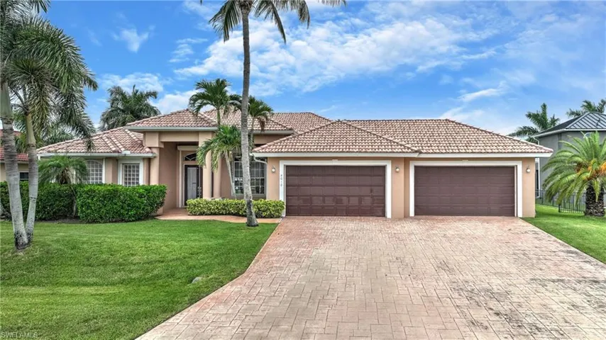 Stucco exterior residence featuring a tile roof and a stamped concrete driveway