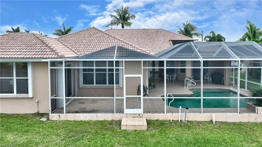 Expansive screened-in pool enclosure featuring a tiled roofline