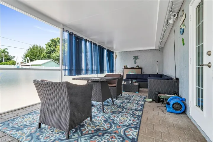 Covered patio featuring paver flooring, a white ceiling, and a full-light entry door