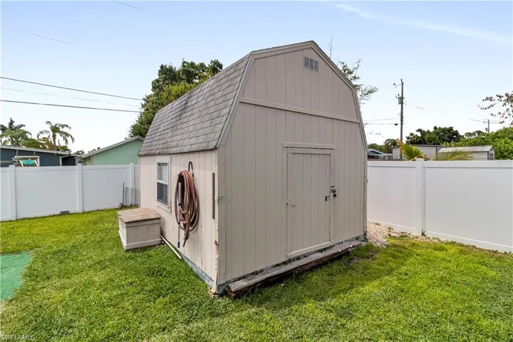Outdoor storage shed with a gambrel roof and vertical panel siding