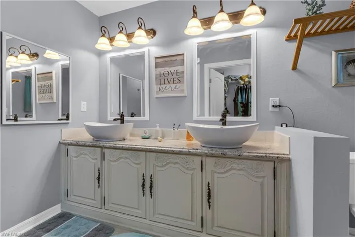 Dual vessel sinks with bronze-finish single-handle faucets set into a light-colored countertop
