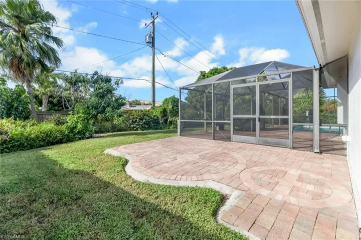 View of yard featuring a patio area, a lanai, a sunroom, and an outdoor pool