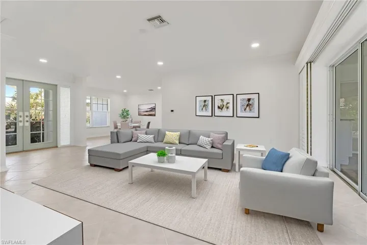 Living area with french doors, healthy amount of natural light, light tile patterned floors, and recessed lighting