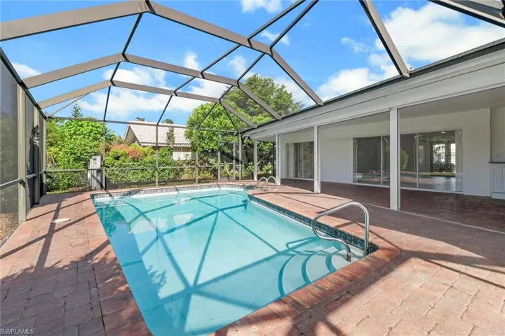 Swimming pool featuring a patio area, a sunroom, and a lanai