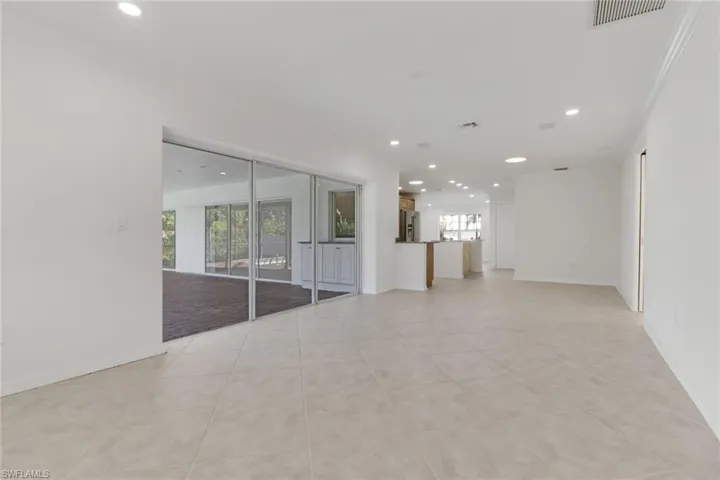 Empty room featuring recessed lighting, light tile patterned flooring, and crown molding