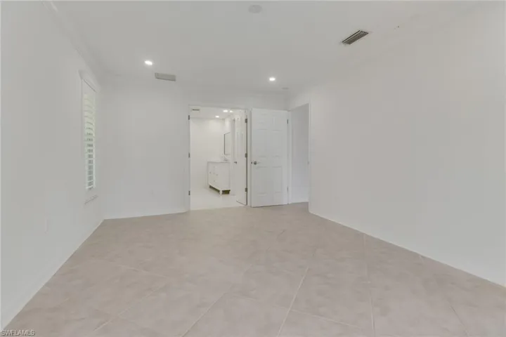Empty room with crown molding, light tile patterned flooring, and recessed lighting