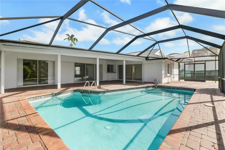 Swimming pool featuring a sunroom, a patio, and a lanai