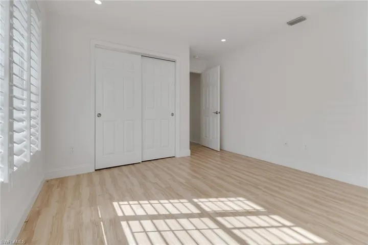 Unfurnished bedroom with light wood-style floors, recessed lighting, and a closet